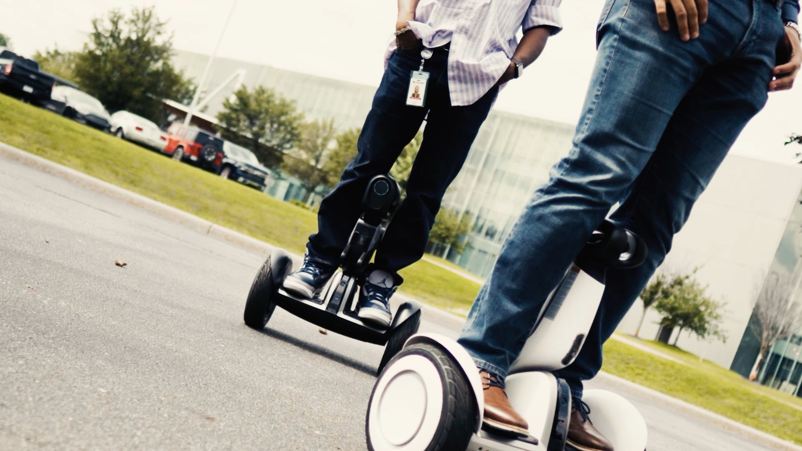 Two employees riding self-balancing scooters outside