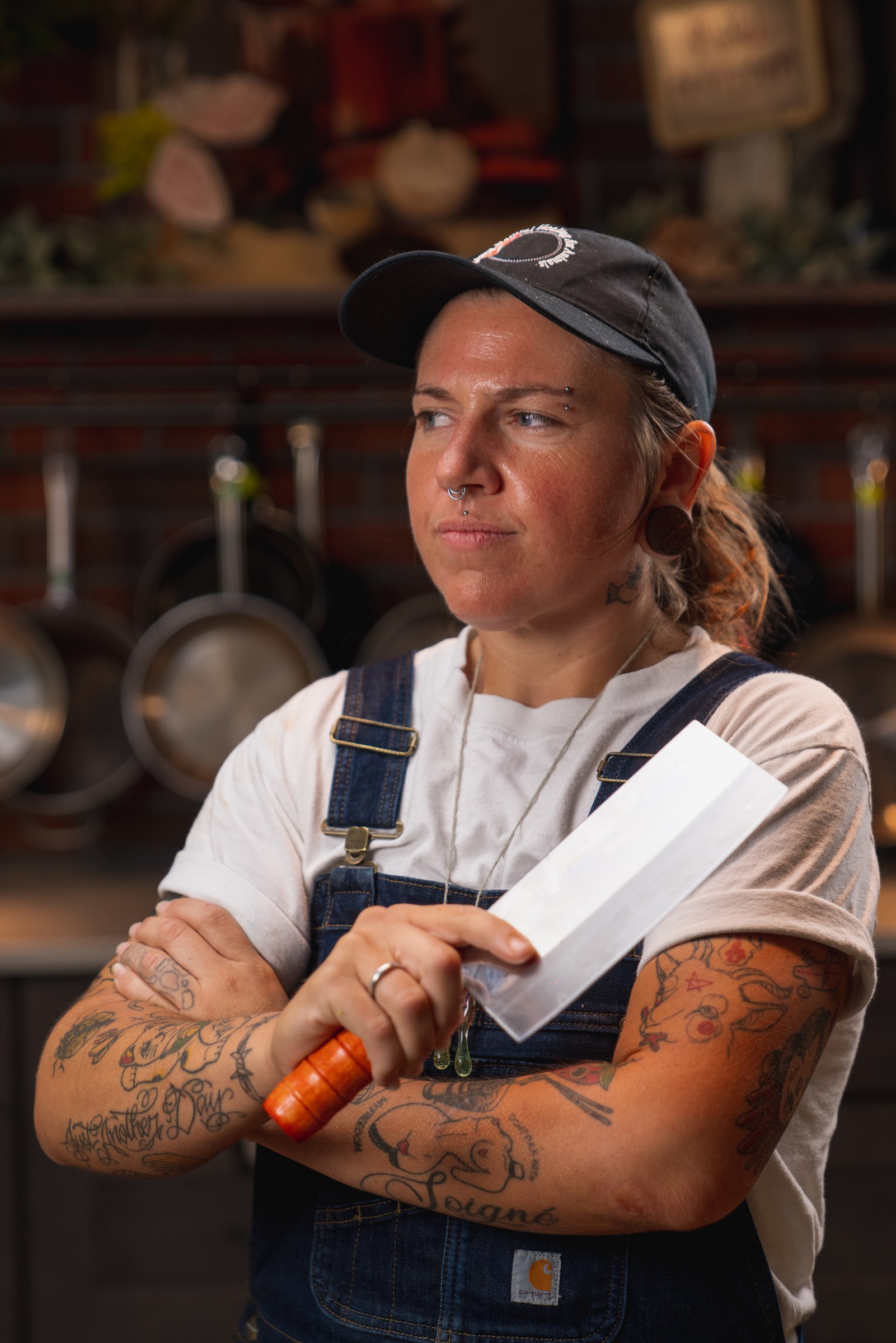 The same cook, serious, holding a cleaver