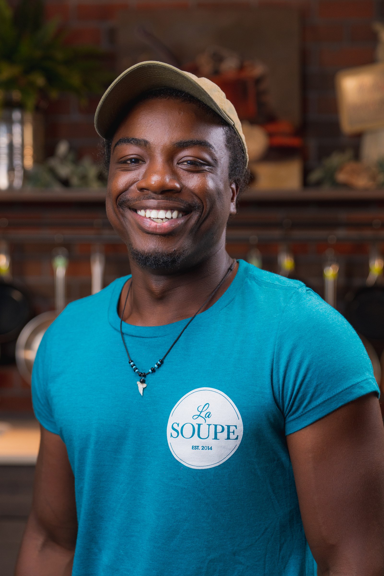 Smiling volunteer in a teal La Soupe shirt
