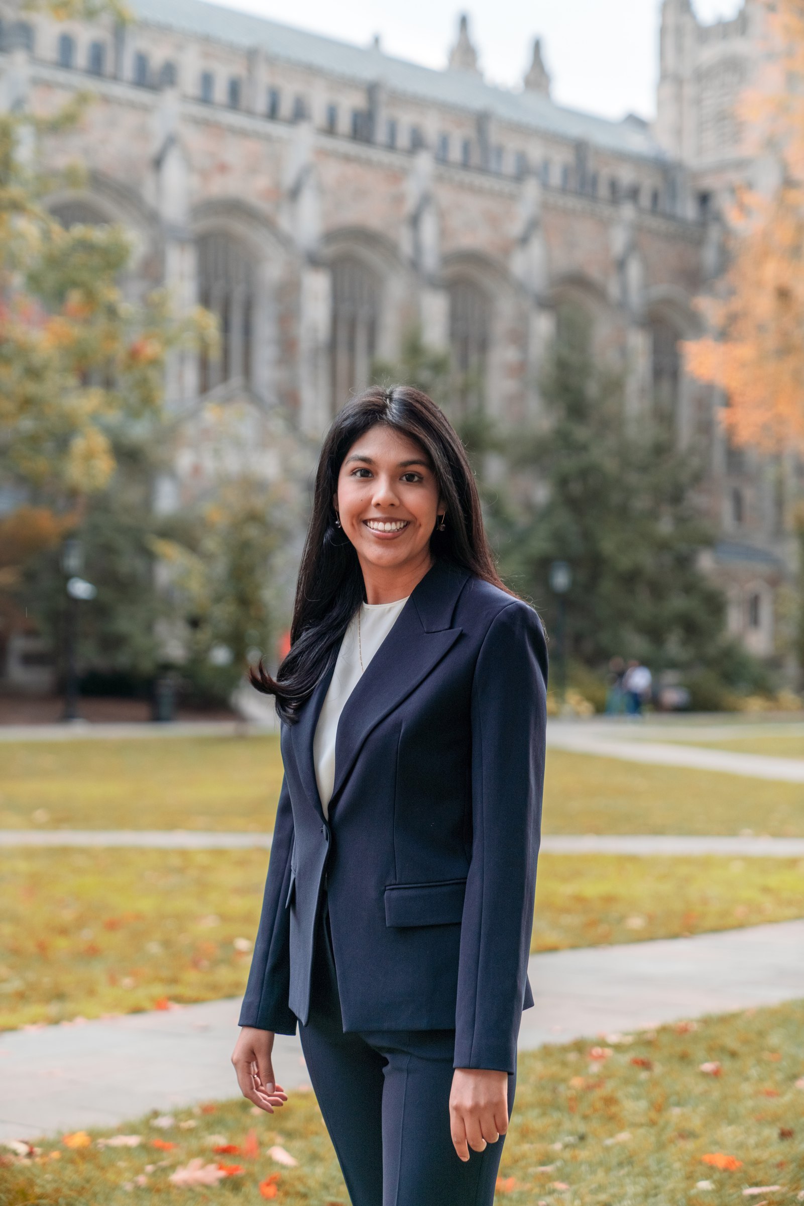 Woman in a navy suit on the quad in autumn