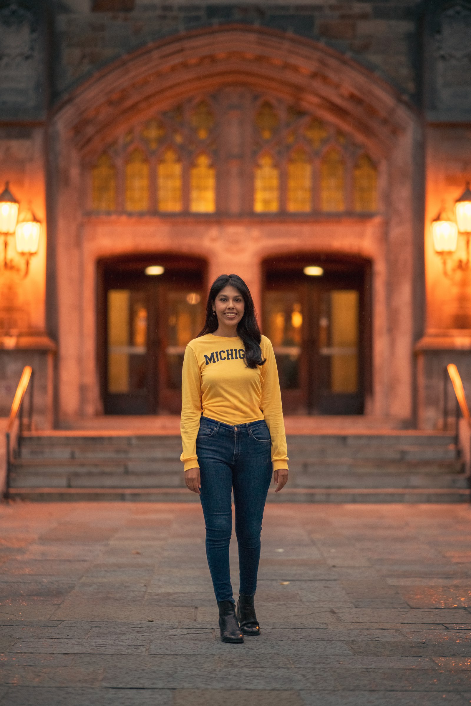 Woman in a Michigan sweatshirt in front of a gothic stone doorway