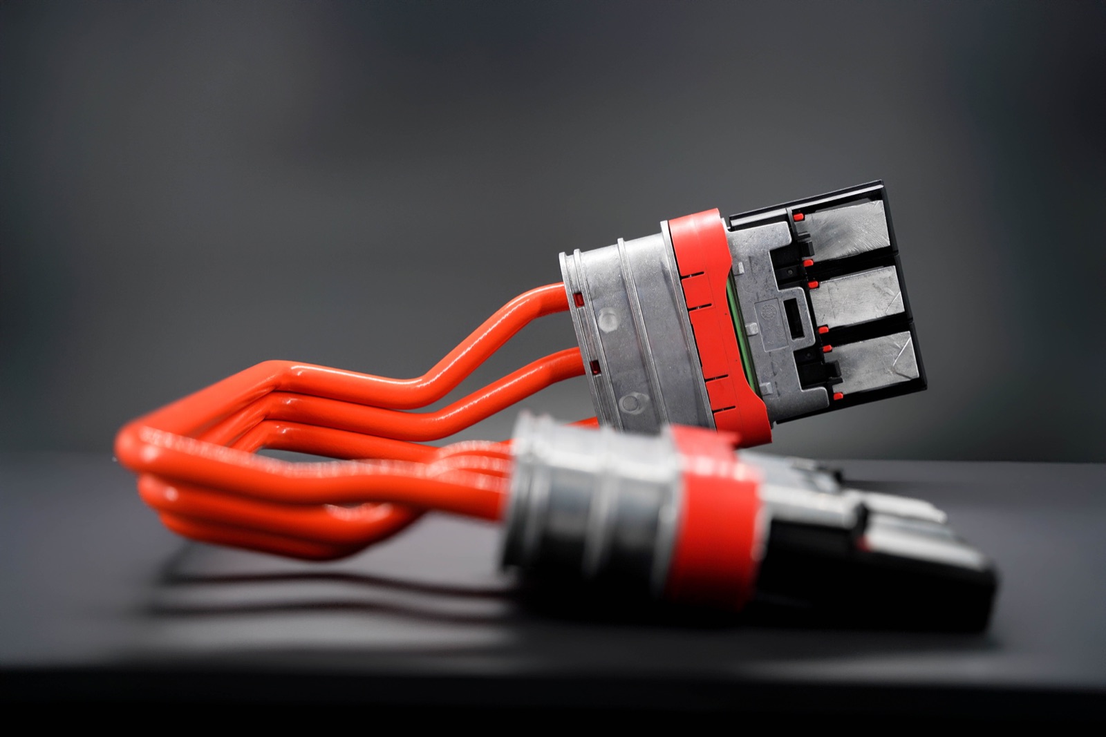 Orange busbar connector on a dark surface