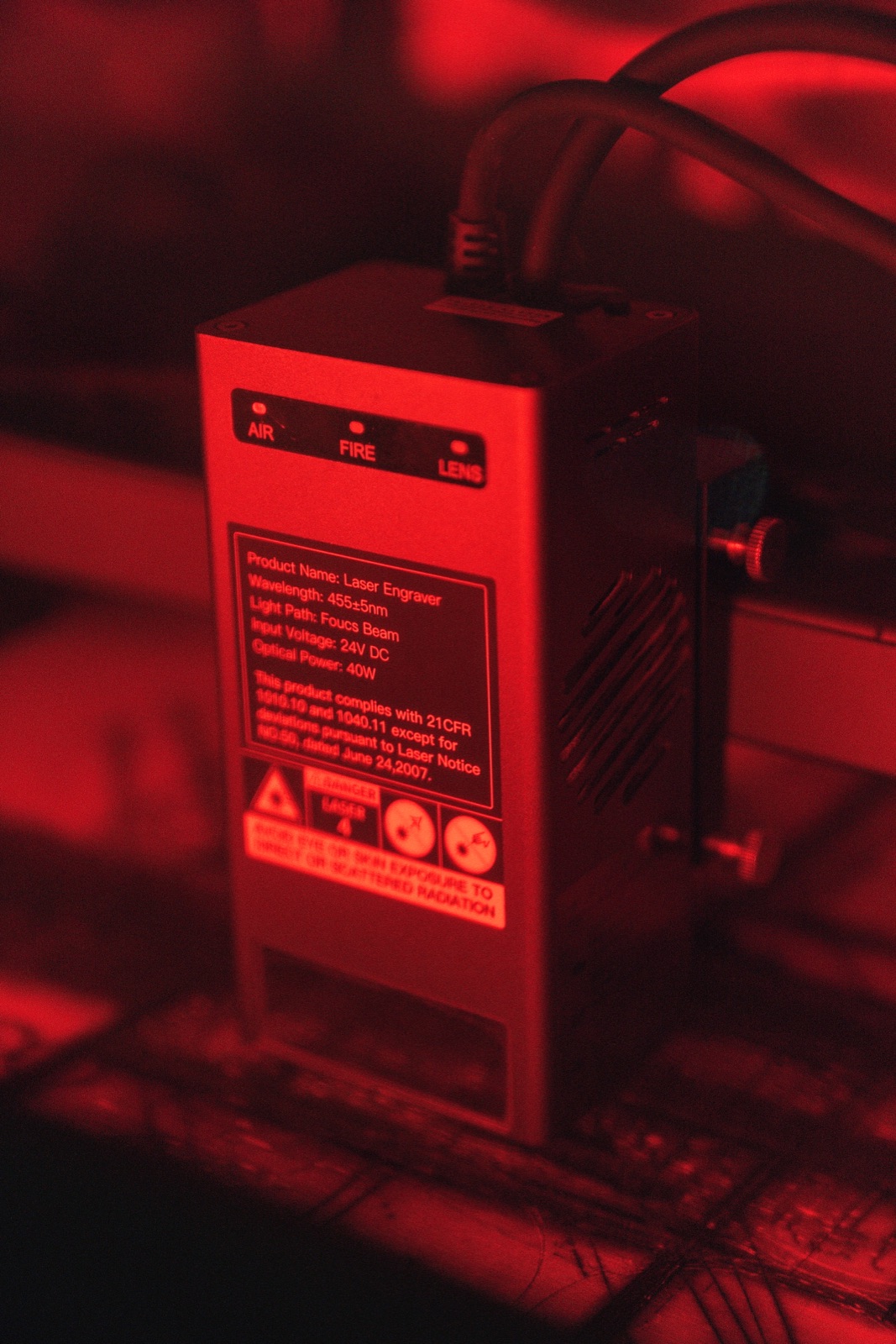 Close-up of a laser module under red light