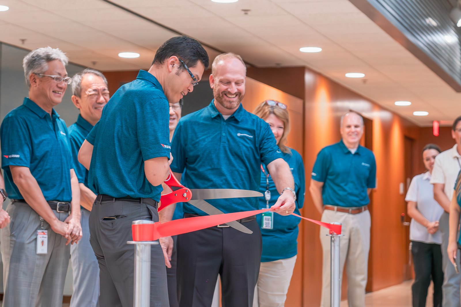 Yazaki leaders cutting the red ribbon to open the Makerspace