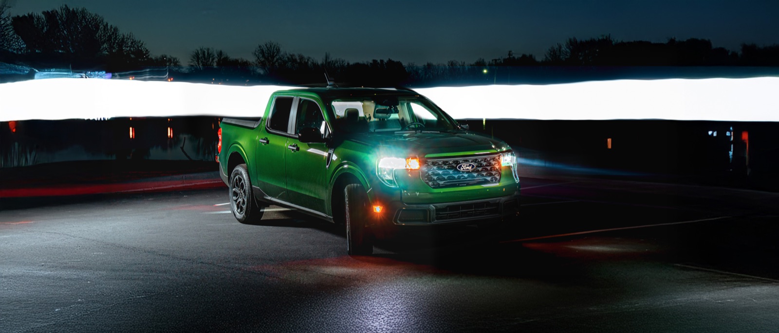 Green pickup truck lit at night with light trails