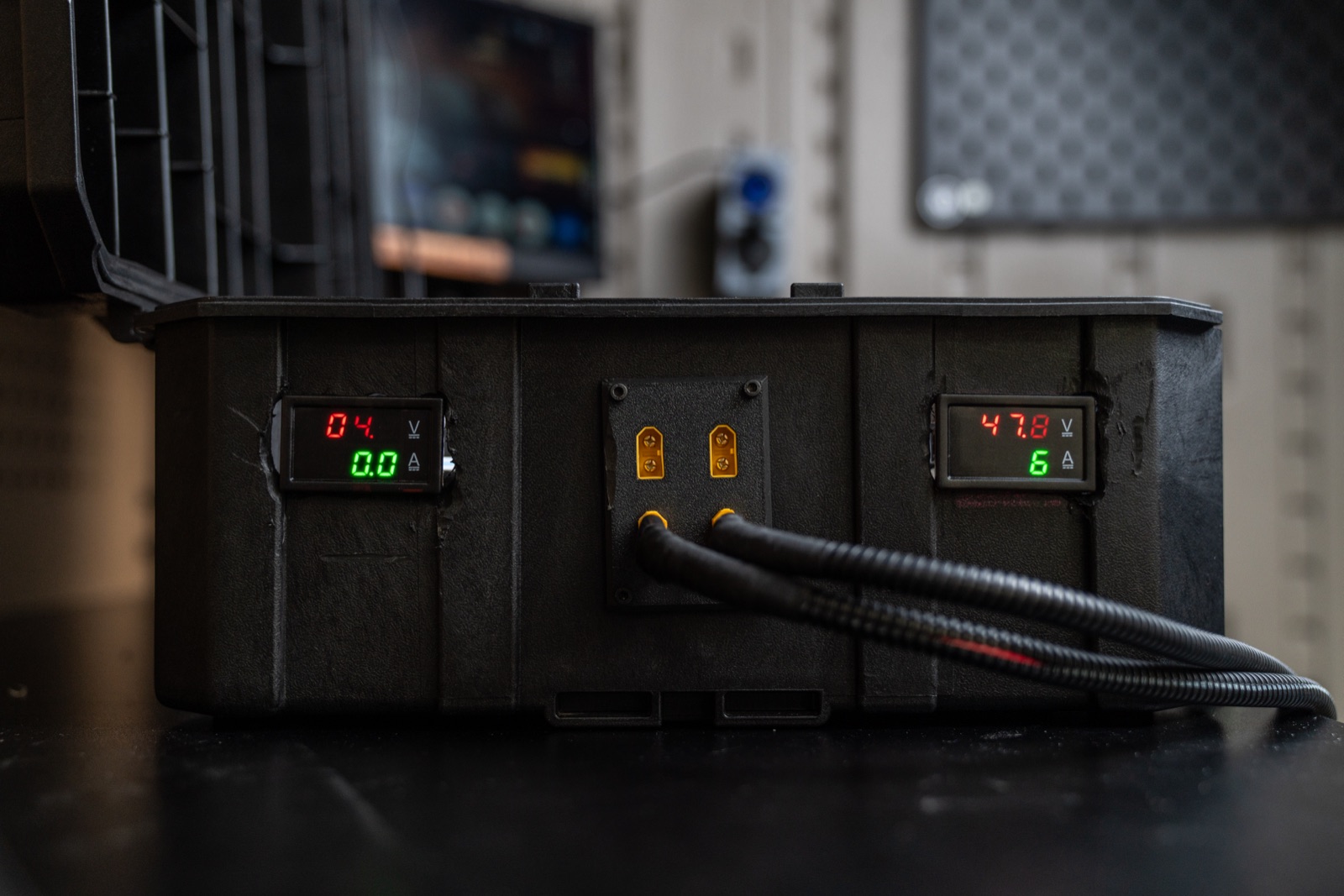 Wall-mounted charging unit glowing in a dark shed