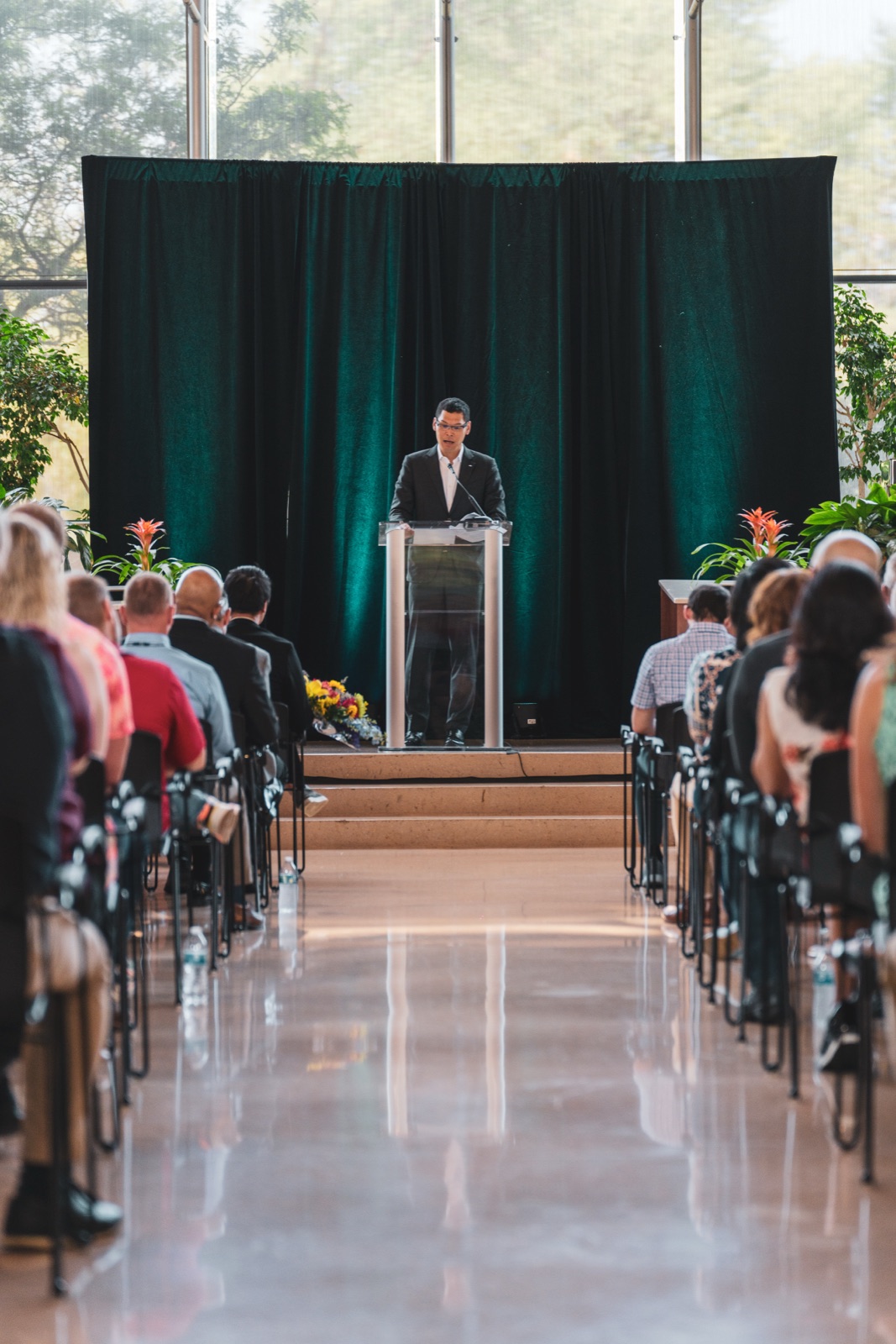 Speaker at a podium in front of a seated crowd