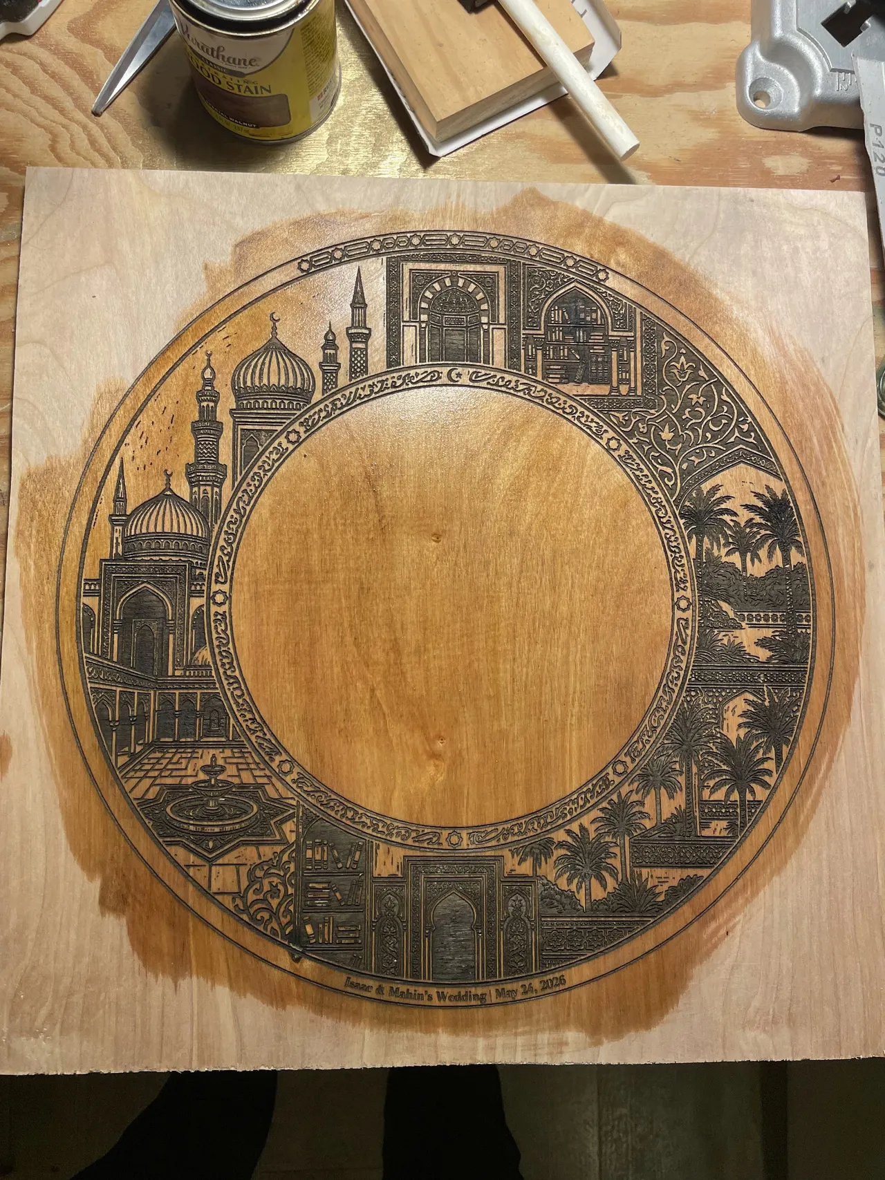 A stained wood panel engraved with a ring of domes, towers and palm trees