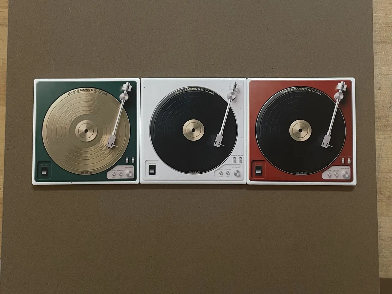 Three square coasters printed to look like record turntables, in green, black and red