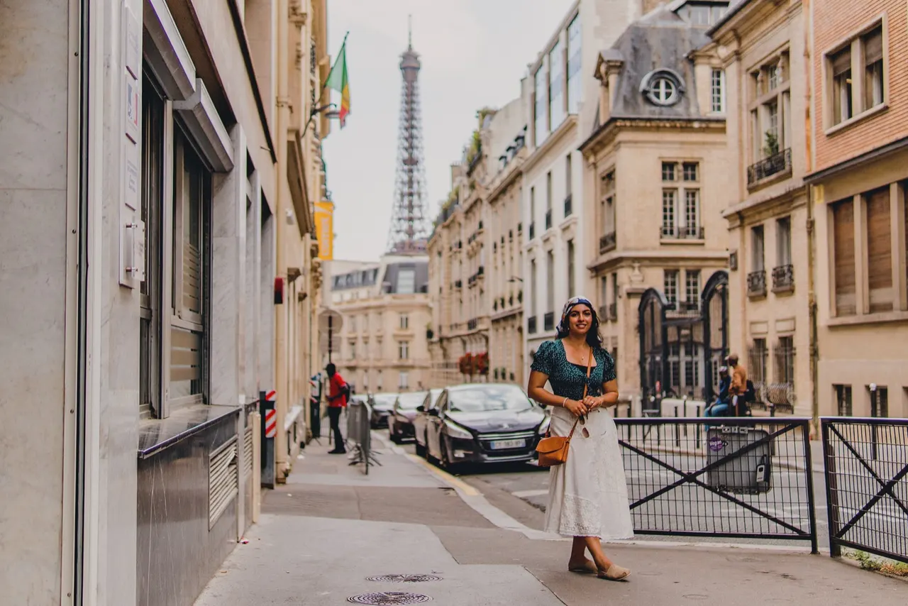 A woman on a Paris street with the Eiffel Tower down the block