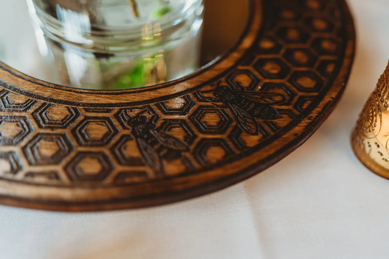 Close-up of a honeycomb pattern with bees engraved in a wooden ring