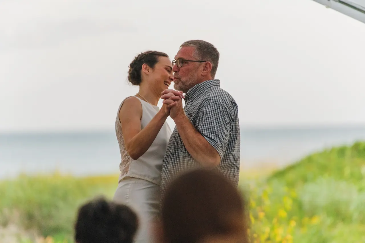 Bride dancing with her father by the lake