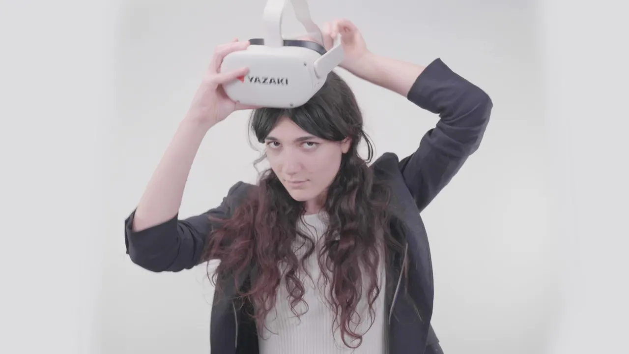 A woman putting on a white Yazaki VR headset against a white wall