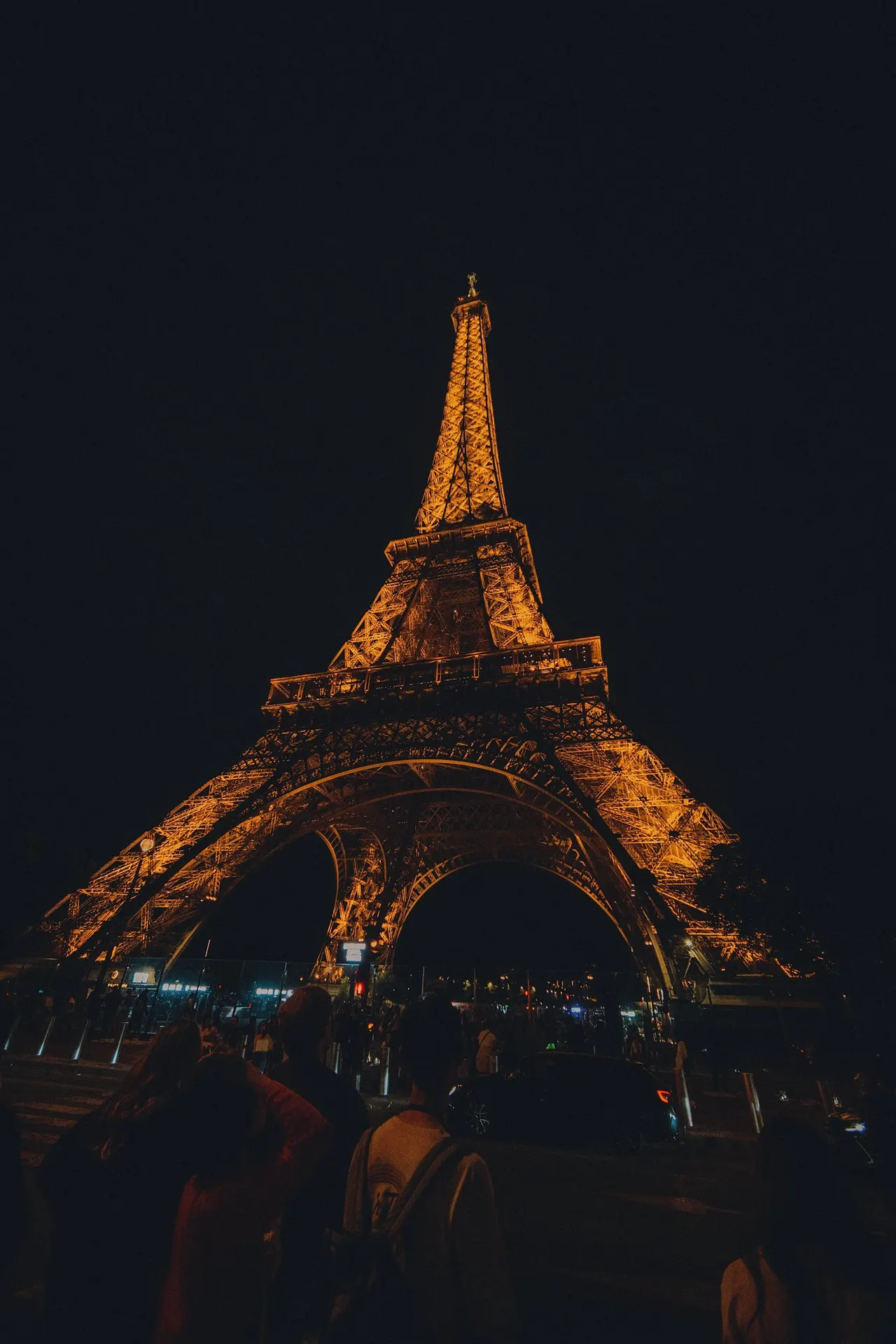 The Eiffel Tower lit gold against a black sky