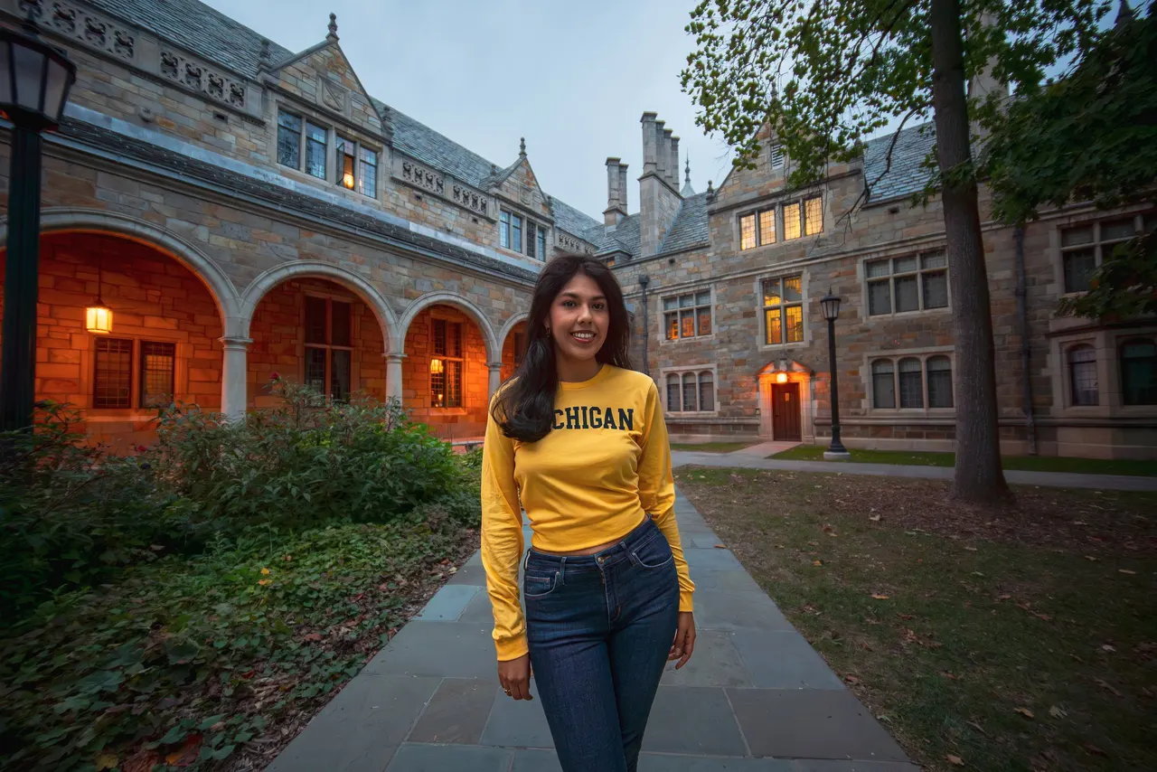 Woman in a Michigan sweatshirt on a stone walkway on campus